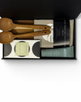 Natural housewarming gift box featuring wooden salad servers, solid cheese board, Alive hand cream, hand screen-printed linen tea towel and Koko Black chocolate.