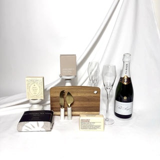 Pol Roger champagne celebration home settlement gift box.  Curated selection of cheese knives, wooden board, soap, hand printed linen tea towel, Loco Love chocolate and Ecosoy soy candle.  Australia wide delivery.